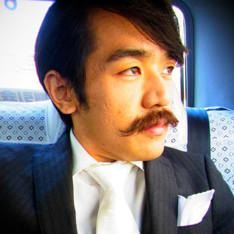 asian man with mustache in the back of a car