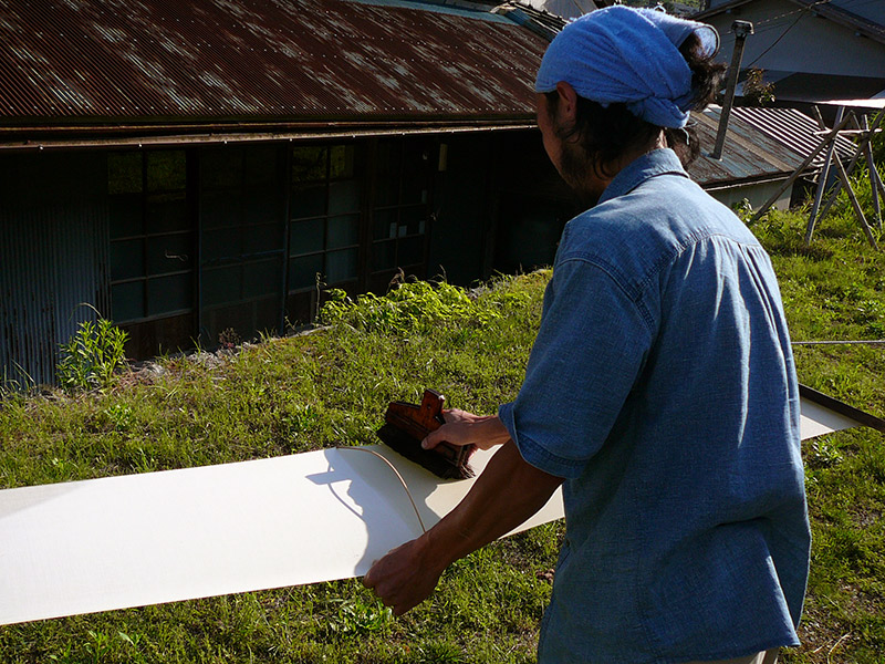 japanese man brushing blue cloth tenugui