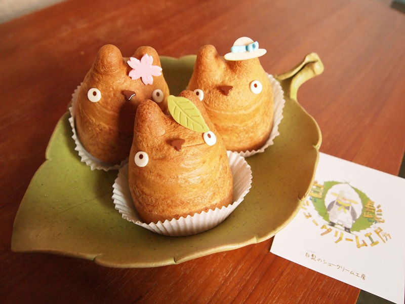 trio of totoro pastries sitting on leaf plate at cafe