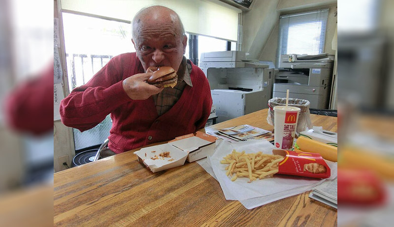 Shigeru Mizuki eating a hamburger