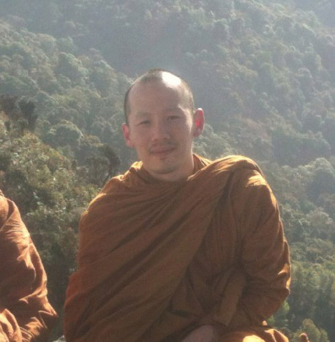 man dressed in monk clothes green forest