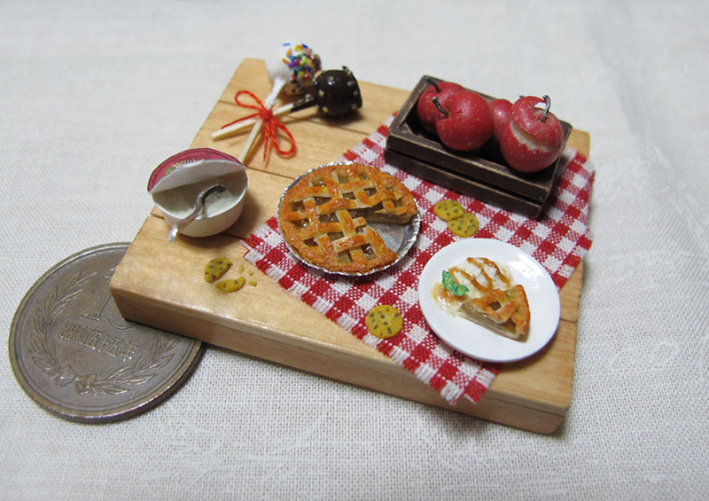 A miniature apple pie set next to a 10 yen coin. The pie is about 25 percent smaller