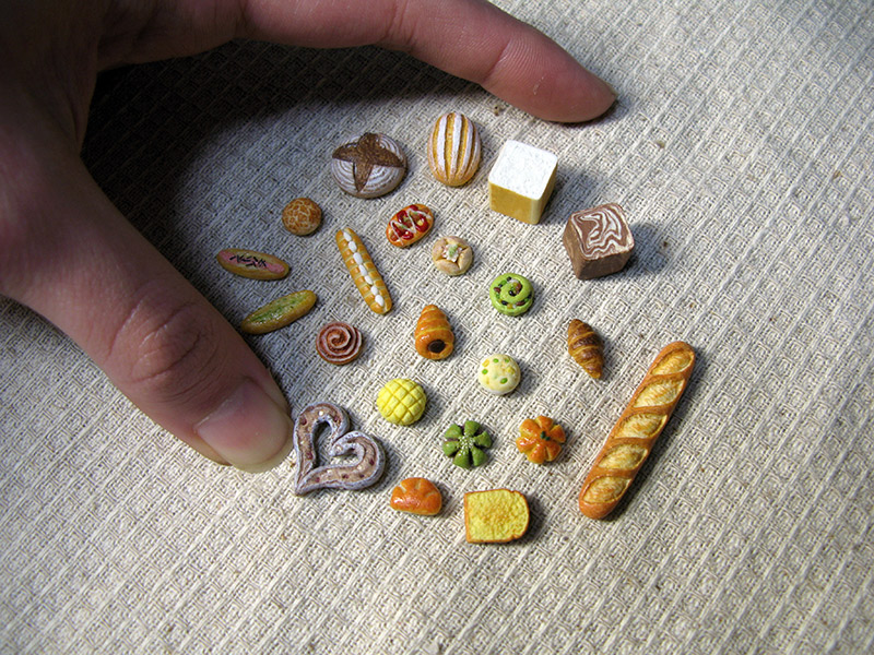 A group of miniature bread encircled by a normal-sized hand