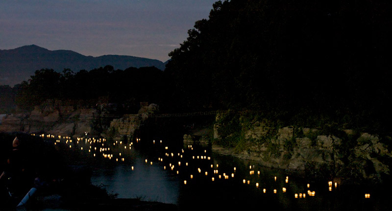 Obon lanterns float down a river