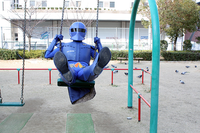 Rapi:tldier the Japanese superhero swings on a swing set