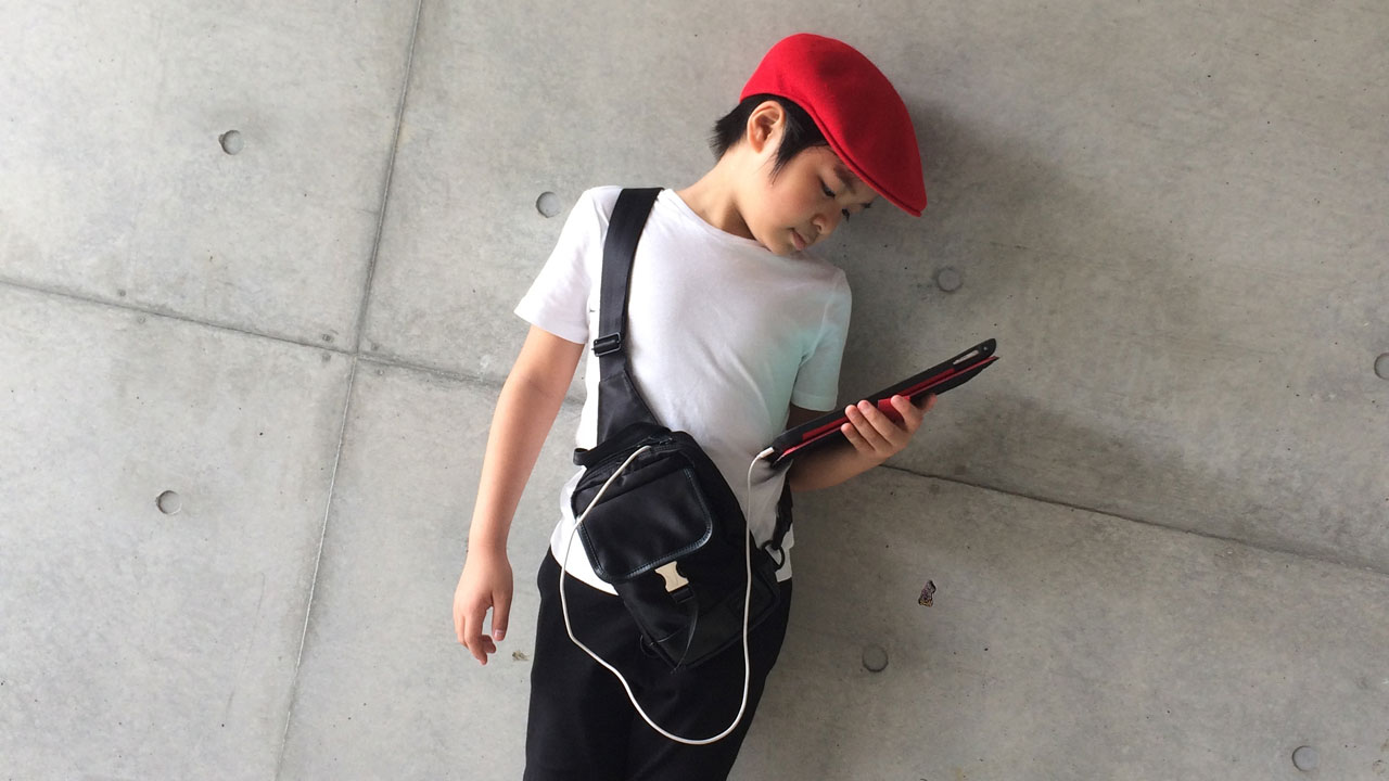 bao nakashima holding ipad in front of gray wall