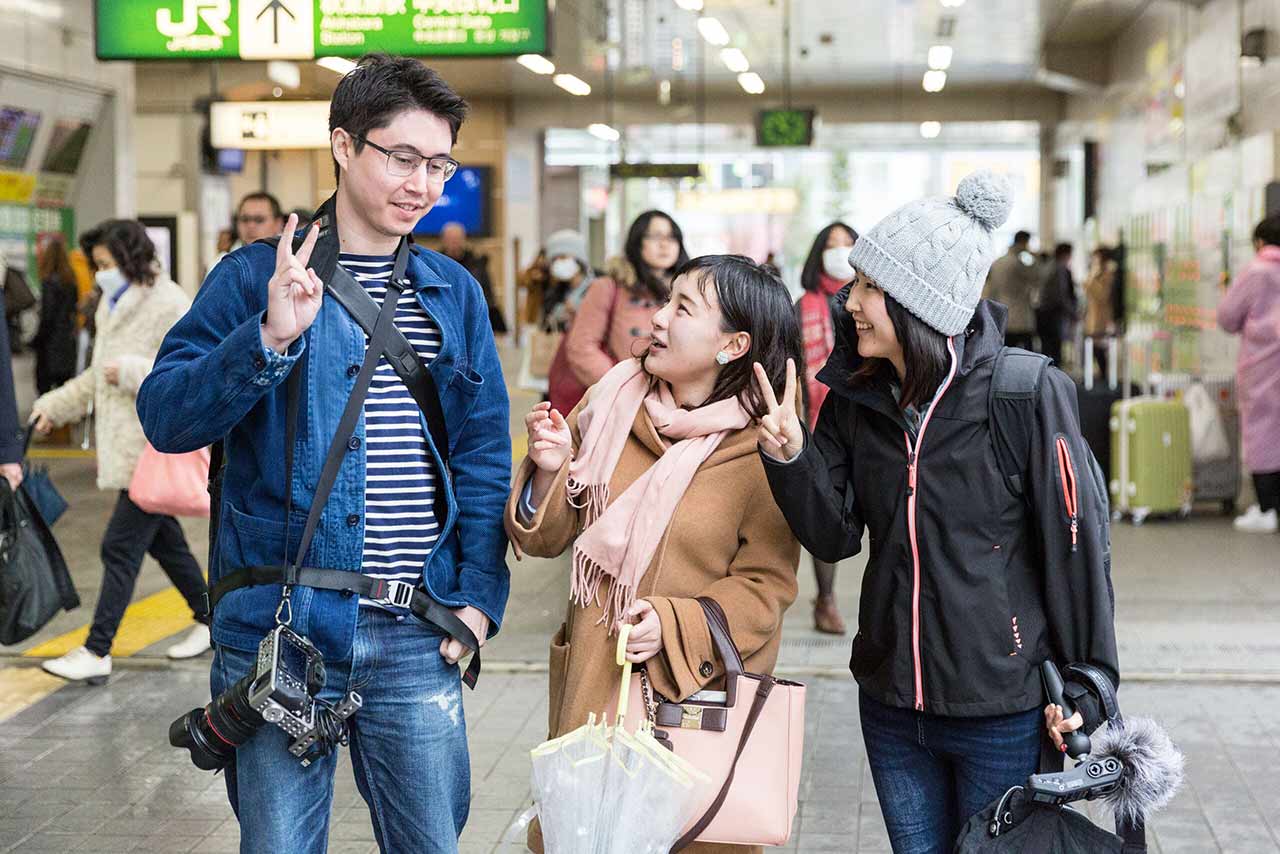 Koichi, Mami, and Mio doing peace signs, with Koichi looking sad because he can't do peace signs good