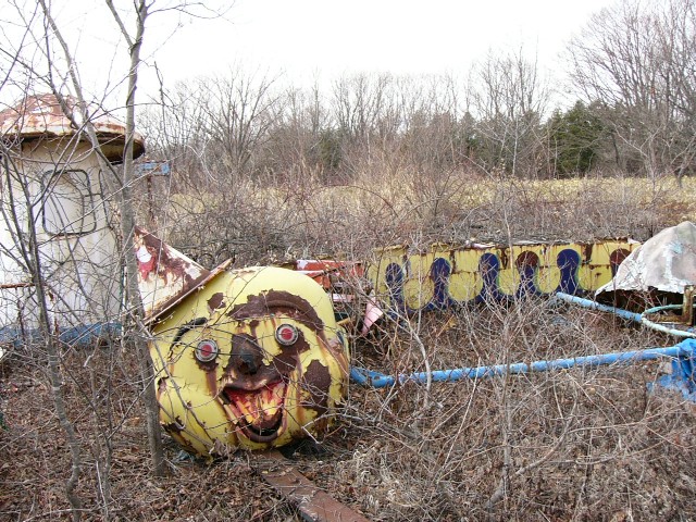 A rusty clown train at an abandoned Japanese amusement park