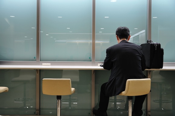 businessman sitting on stool seen from behind