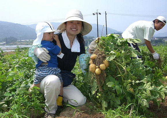 a woman holding a child at a wwoof japan farm