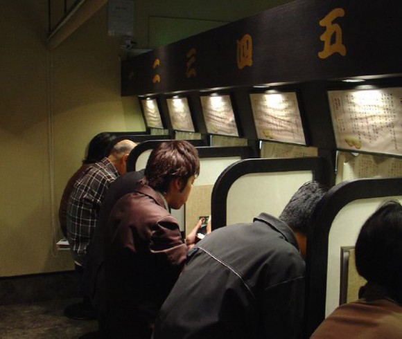 Ichiran Ramen inside restaurant booths with people eating ramen