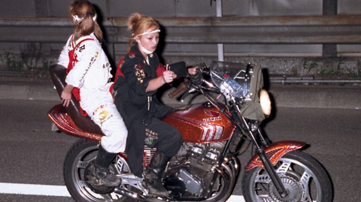 two people with perms on a motorcycle