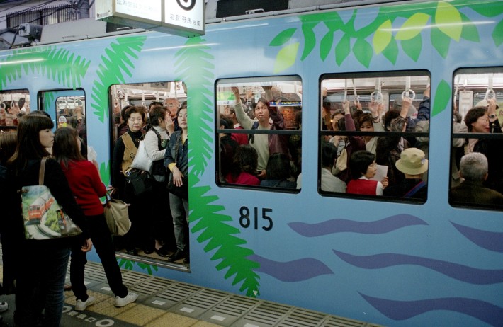 japan stereotype of packed commuter train with japanese travellers