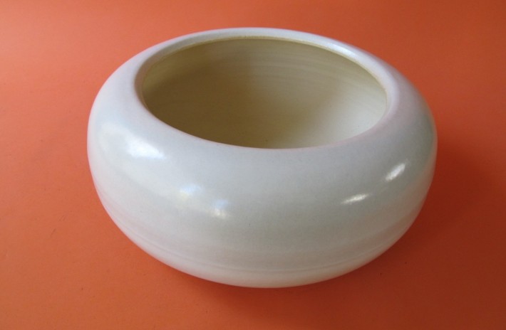 white traditional hibachi fire bowl on bright orange background