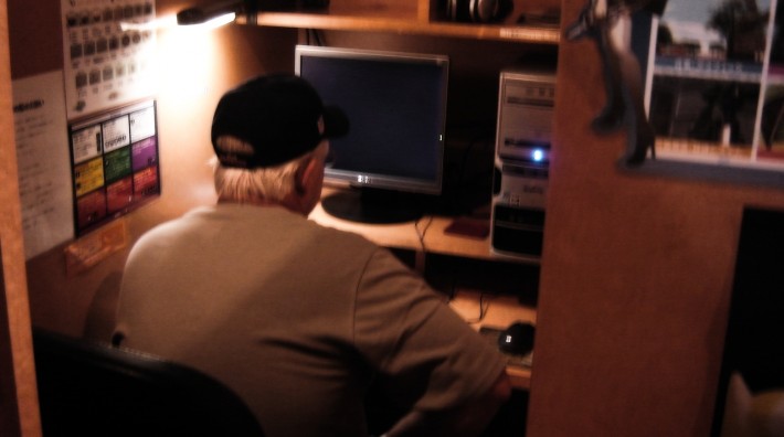 Man in a small cubicle in front of a computer