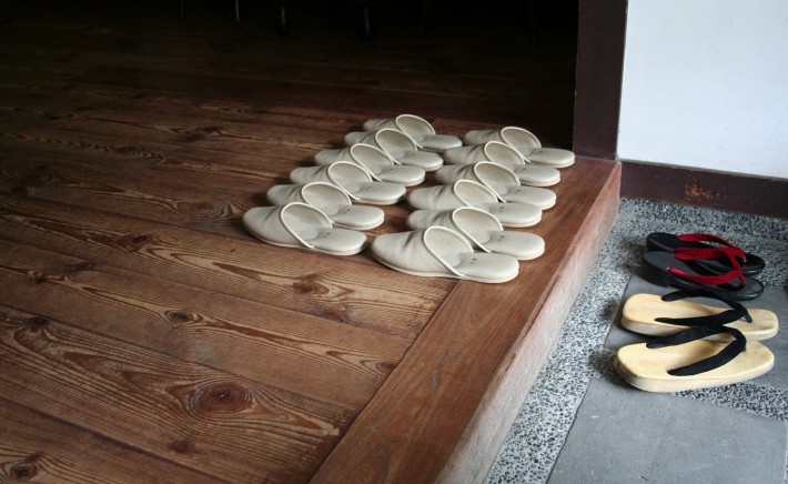 A Japanese entryway with a row of house slippers 