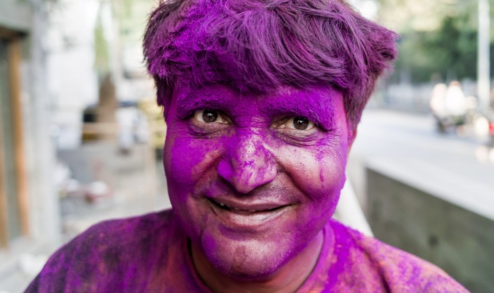 A man covered in purple powder