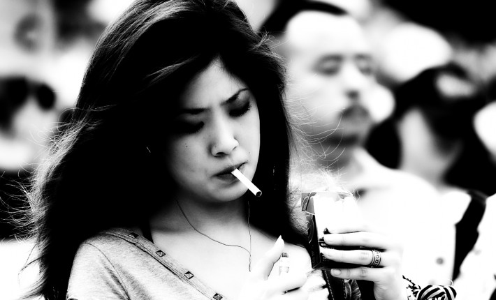 Japanese woman walking while smoking a cigarette