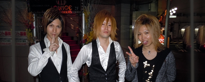 three male hosts posing on street