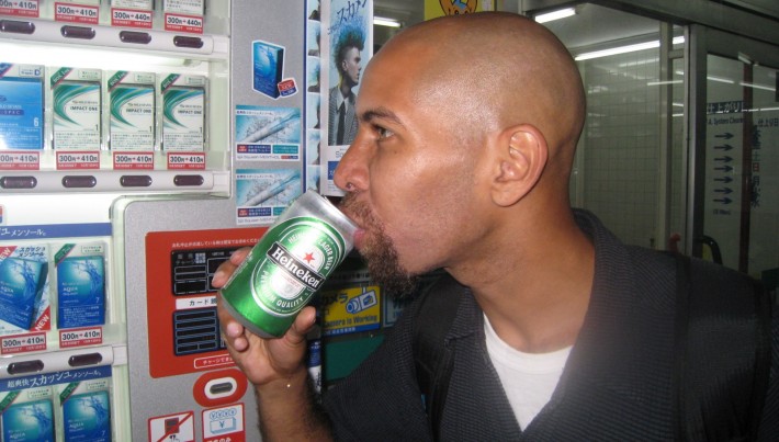 A man drinking a can of beer out in public
