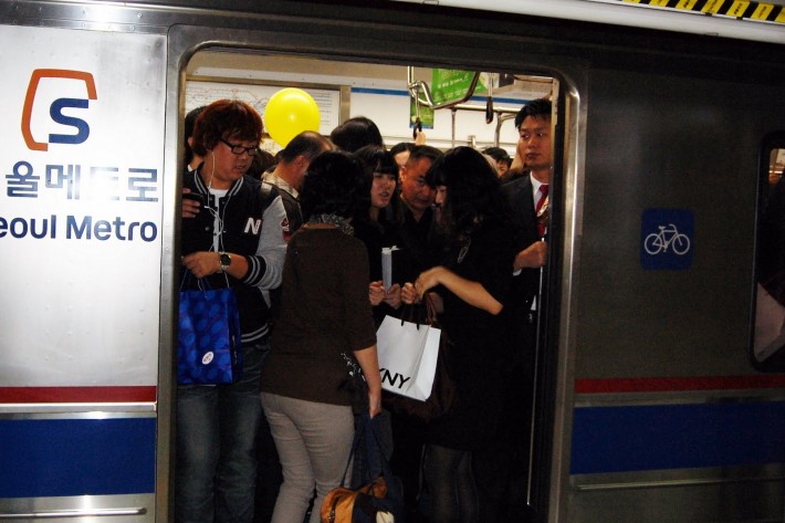 Passengers entering a packed subway car at rush hour