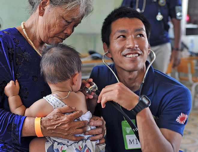 doctor examining infant with stethoscope