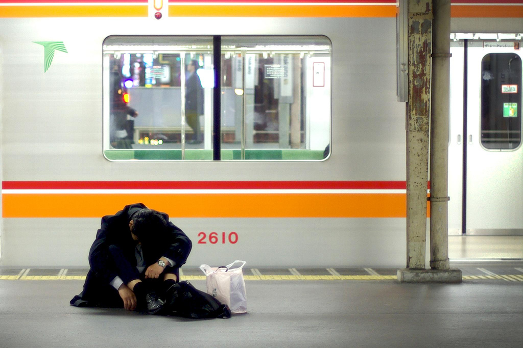 sleepy salaryman waiting for the train