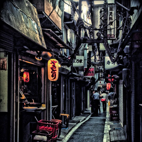 two people walking through piss alley in tokyo japan