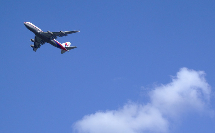 a japanese airliner flying above the clouds