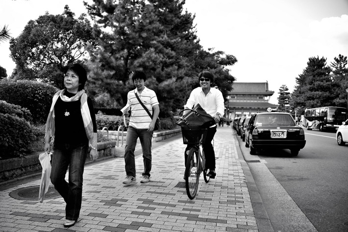 biking down the street in japan around pedestrians