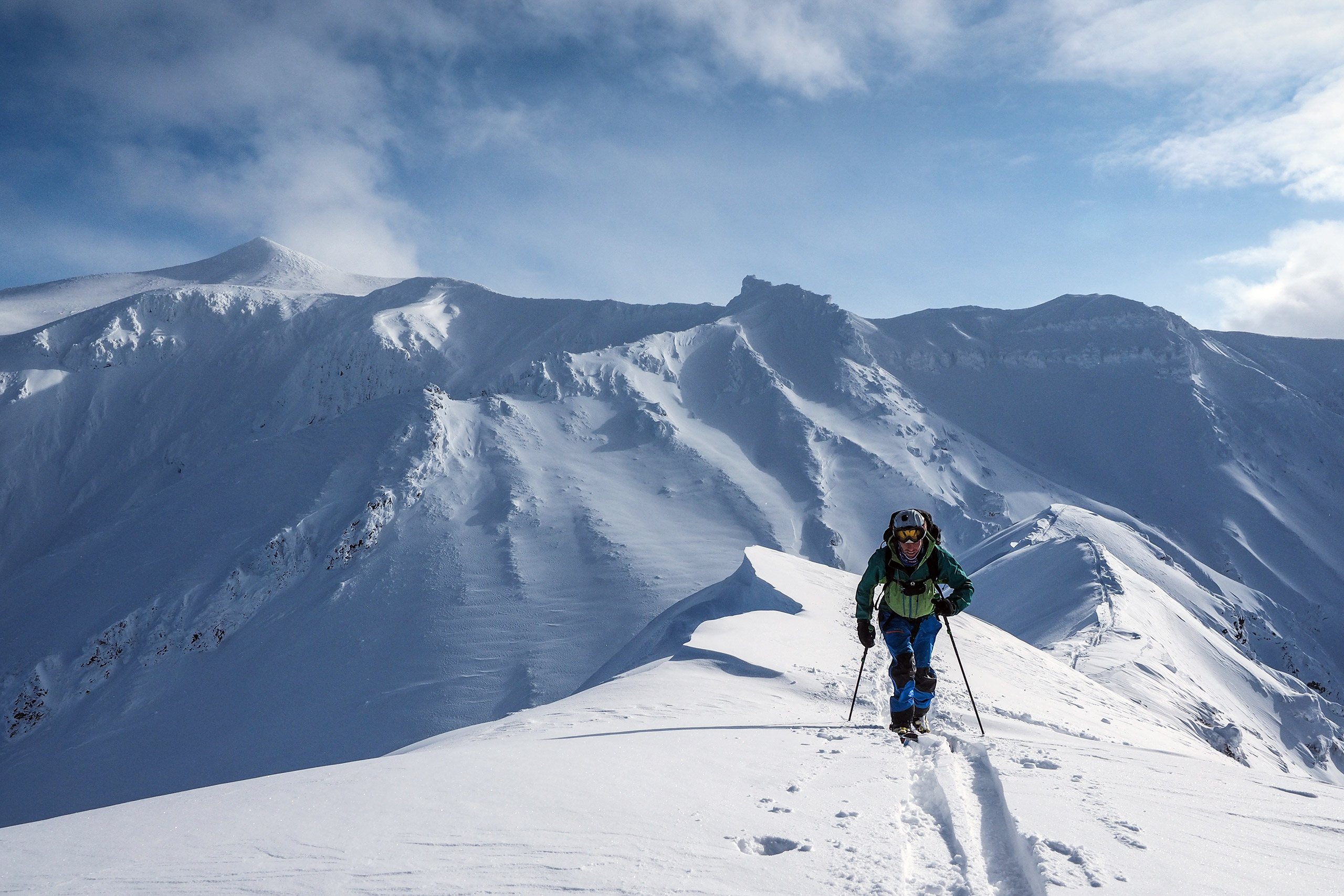 skier walking across a snowy mountain