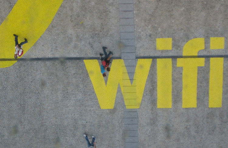 People walking on  the word wifi in yellow block letters