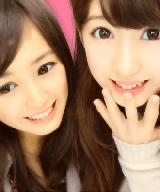 two girls in purikura with big eyes