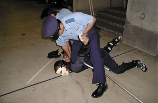 police officer restraining man on the ground