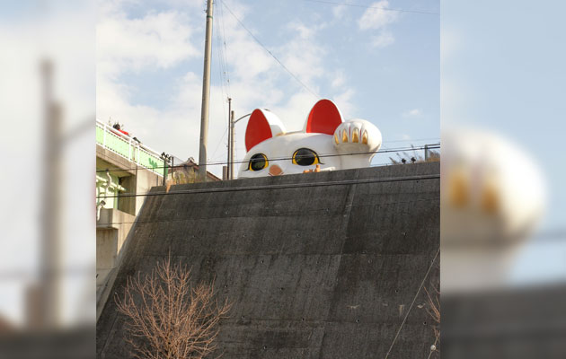 Large Maneki Neko peeking over a wall