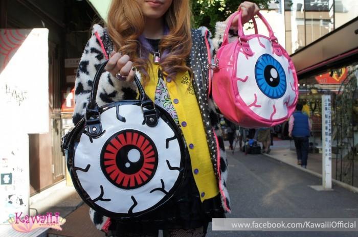 A girl carrying two bags shaped as eyeballs