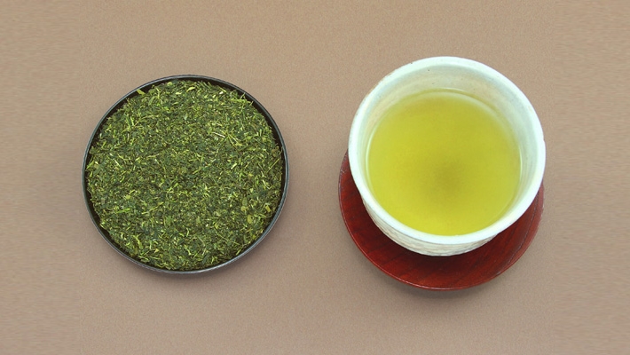 bowl of tea leaves and cup of residual green tea