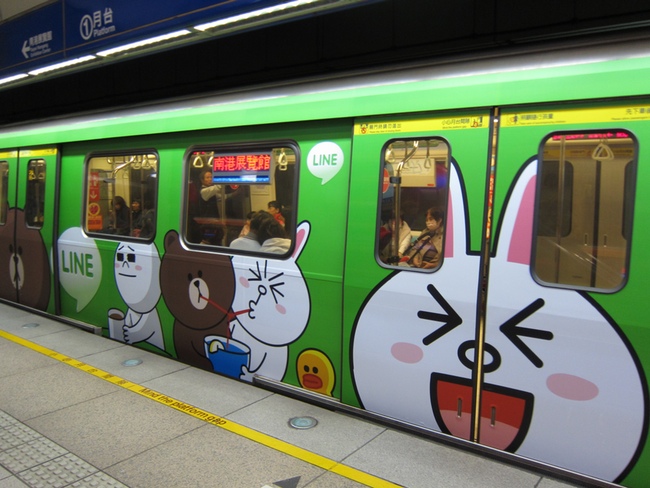 A subway train with an advertisement for LINE