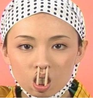Japanese woman makes a weird face with chopstick stuck up her nose