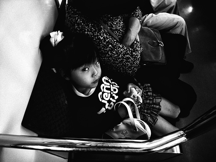 little Japanese girl sitting on train