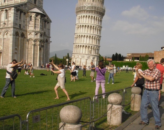 bunch of white people taking the same picture of the leaning tower of pisa