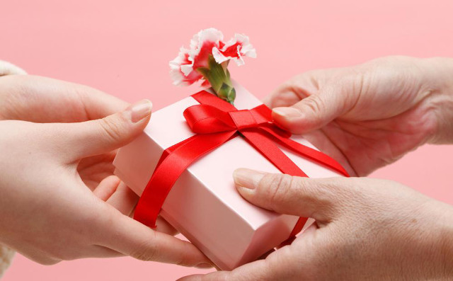 two hands exhanging a present with a flower