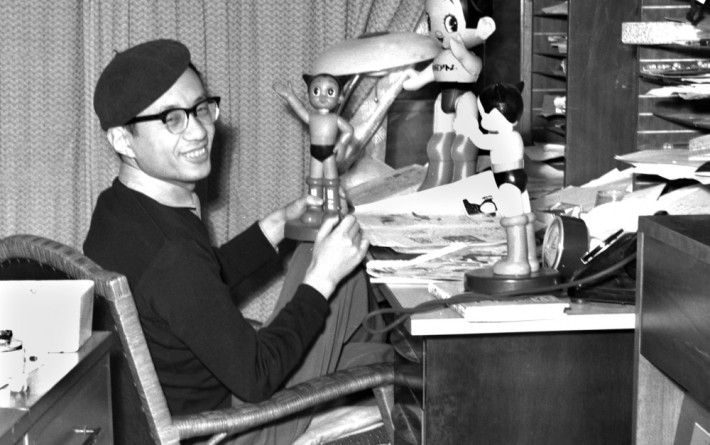 Osamu Tezuka with several statues of Astroboy