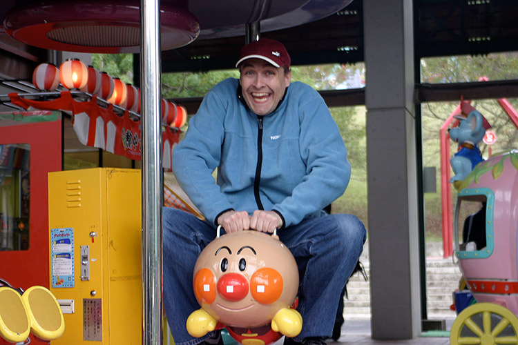 happy foreigner wearing hat is excited about riding anpanman