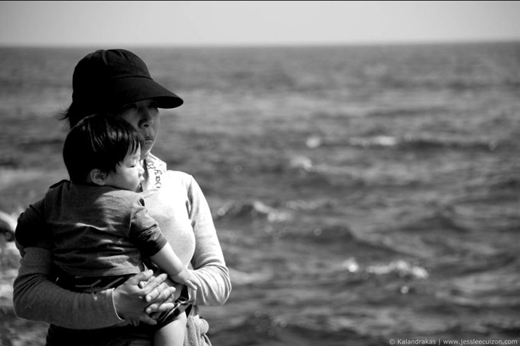 Japanese mother holding child by sea