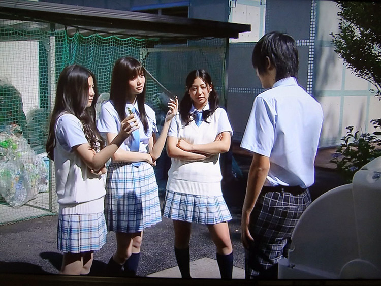 Mean-looking Japanese girls talking to a classmate