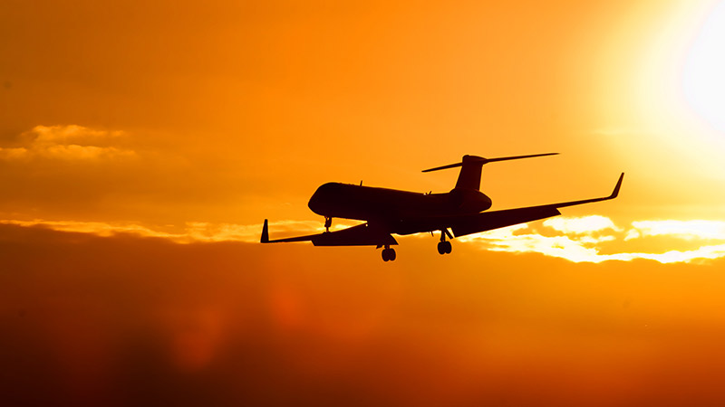 A private jet landing at sunset