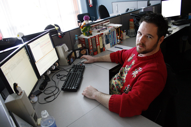 man at cubicle desk with christmas sweater