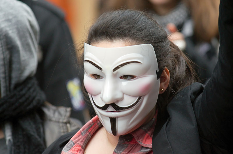 woman wearing Guy Fawkes mask