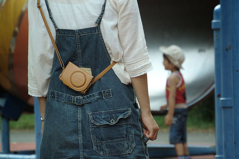 woman in overalls with camera and small boy